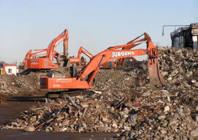 Two Jurgens excavators sorting steel and concrete rubble across the cleared Makarewa site