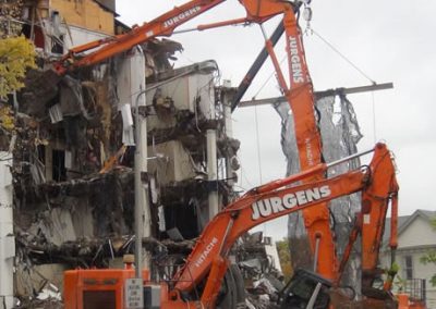 Two Jurgens excavators tearing into the collapsed upper storeys of Scales House