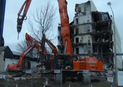 Jurgens excavators with shear attachments working on the remains of Scales House behind site fencing